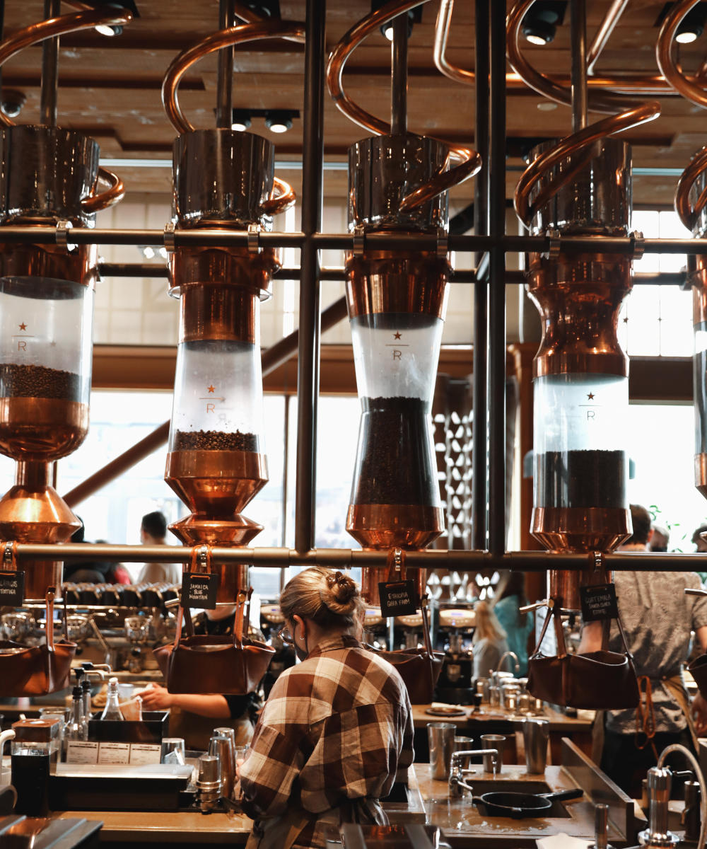 Interior of coffee roasting business with view of equipment and staff.