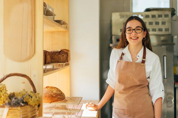 Baker clerk in apron standing at counter