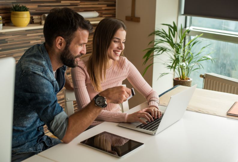 Two people sitting at a desk with a laptop planning to sell their business