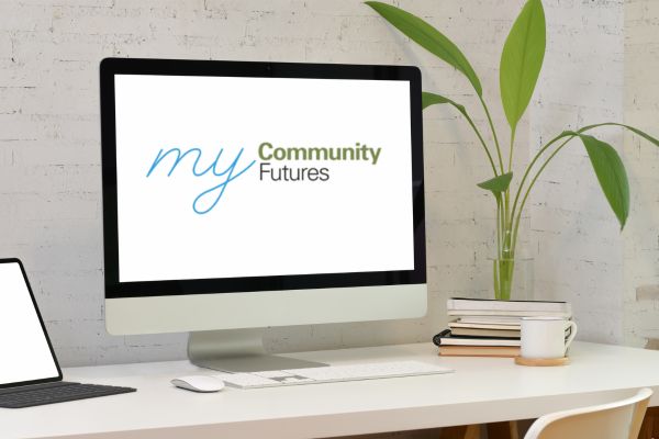 Person seated at desk looking at laptop.